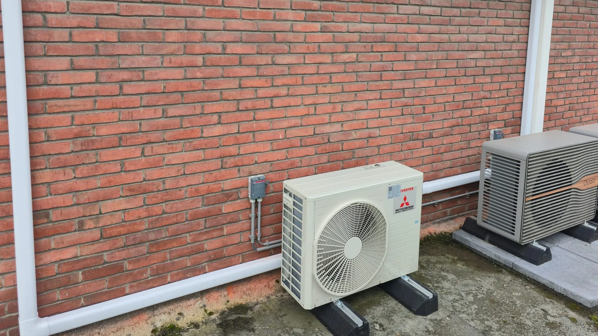 Twee buitenunits van een airco aan een bakstenen gevel